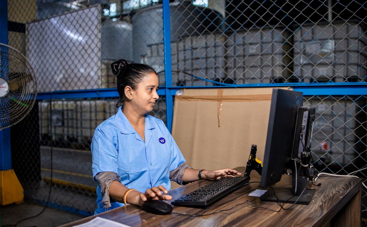 Nhân viên vận hành nhập liệu trên máy tính tại quầy làm việc trong kho hàng